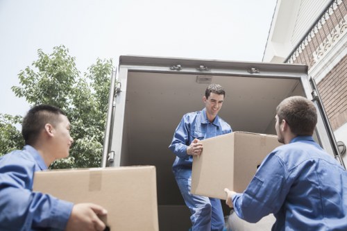 Local movers handling furniture carefully in a West London house move